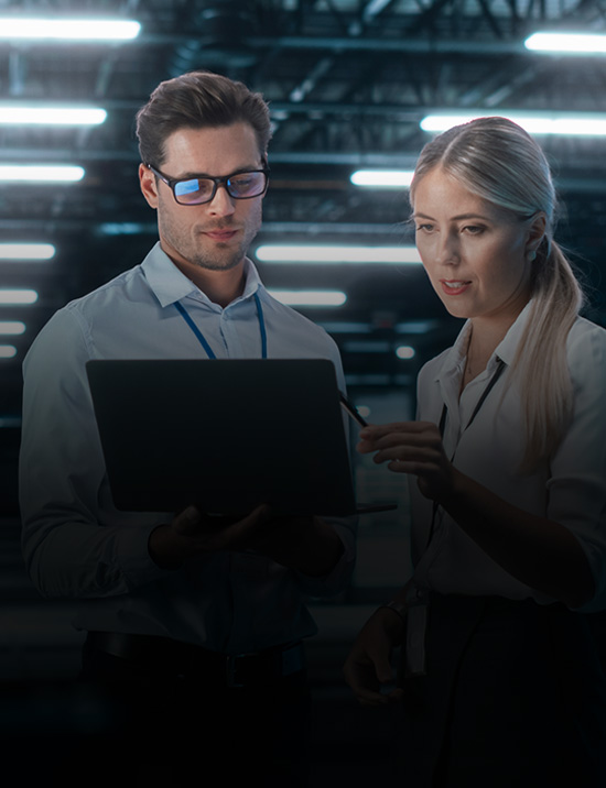 Male and female executive discussing in front of a laptop