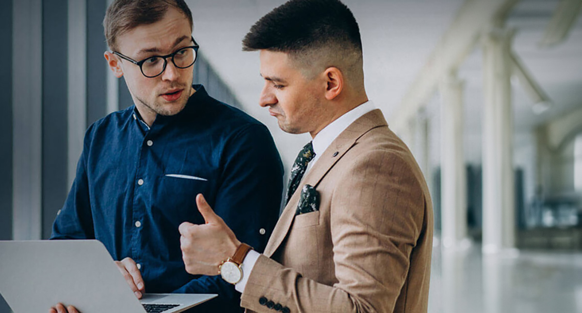 2 male executive discussing in front of labtop with thumbs up